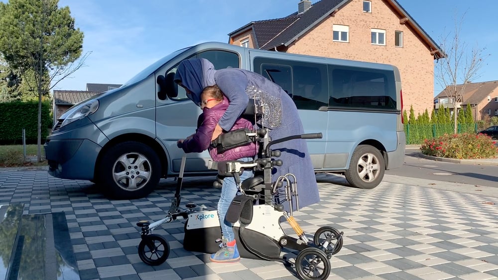 Mamma lyfter ut sitt barn ur Xplore utomhus