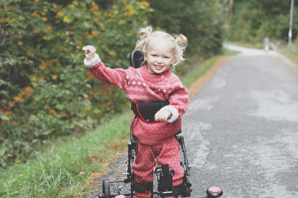 Kleines Mädchen läuft mit Hilfe des NF-Walker