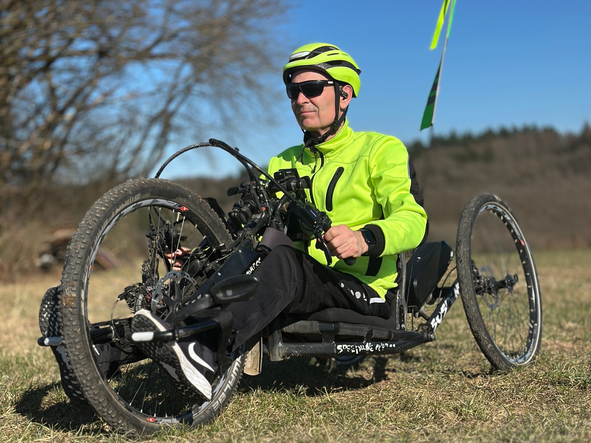 Mann sitzend im Handbike in der Natur.