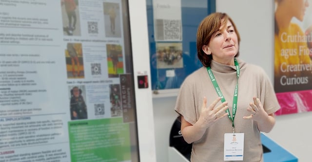 Idoia presents her research poster at the EACD conference, explaining the findings beside a large poster display