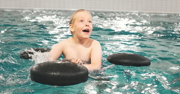 Pojke simmar med sin krabat pirat.