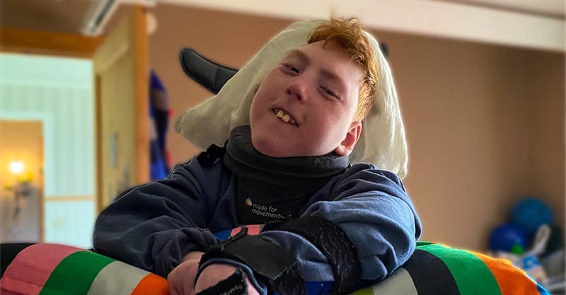 Ludvig, en 10 år gammel gutt, smiler mens han står i sin Innowalk hjemme.