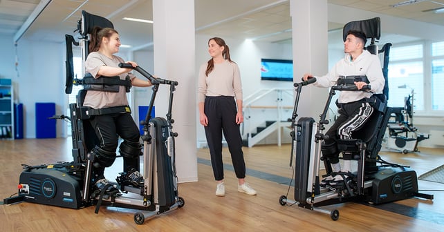 Therapeutin in der Mitte von zwei Patienten beim Training im Innowalk Pro