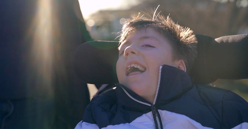Boy is out in his wheelchair in sunny weather