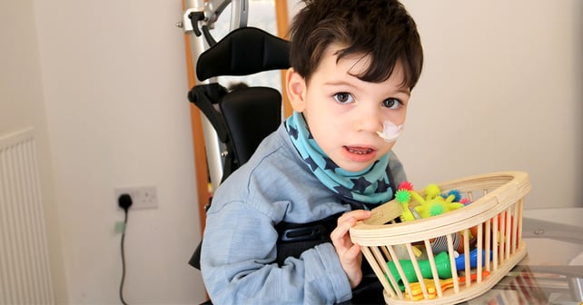 Oliver in seinem Innowalk beim Spielen mit Spielzeug