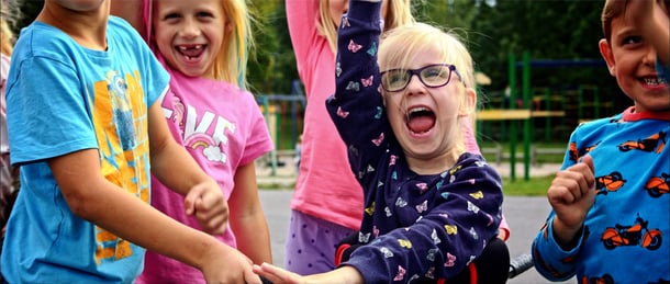Young girl cheers with joy with friends