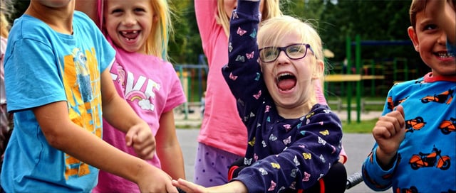 Young girl cheers with joy with friends