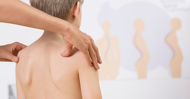 Physiotherapist correcting kids faulty posture with her hands