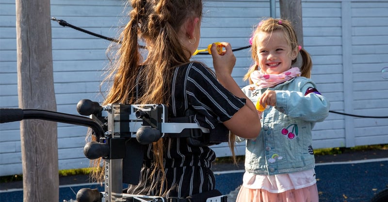Xplore gait trainer allows girl to play upright with her friend