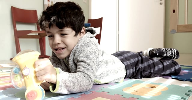 Young boy lying on the floor and playing