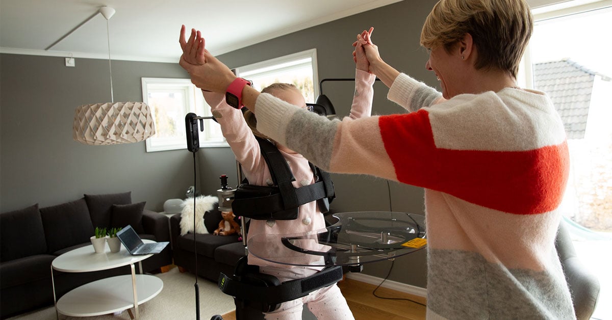 Young girl with Rett syndrome stands in her Innowalk while dancing