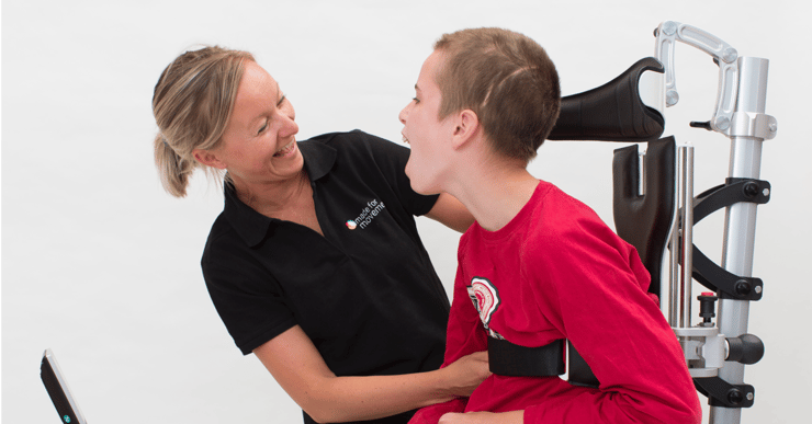 Woman helping a boy adapt the equipment. How to transfer the user in and out of the Innowalk.