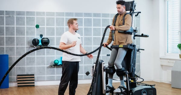 Man on Innowalk is training with ropes whilst guided by a physiotherapist 