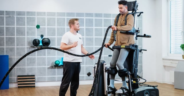 Man on Innowalk is training with ropes whilst guided by a physiotherapist 