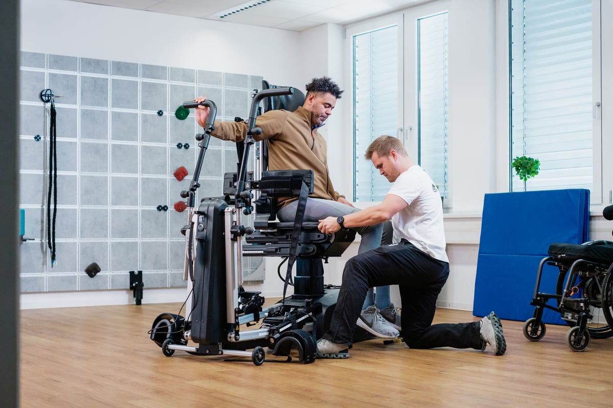Therapeut hilf einem Patienten beim Transfer aus dem Innowalk Pro