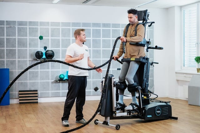 Patient using ropes for arm training standing in the Innowalk Pro