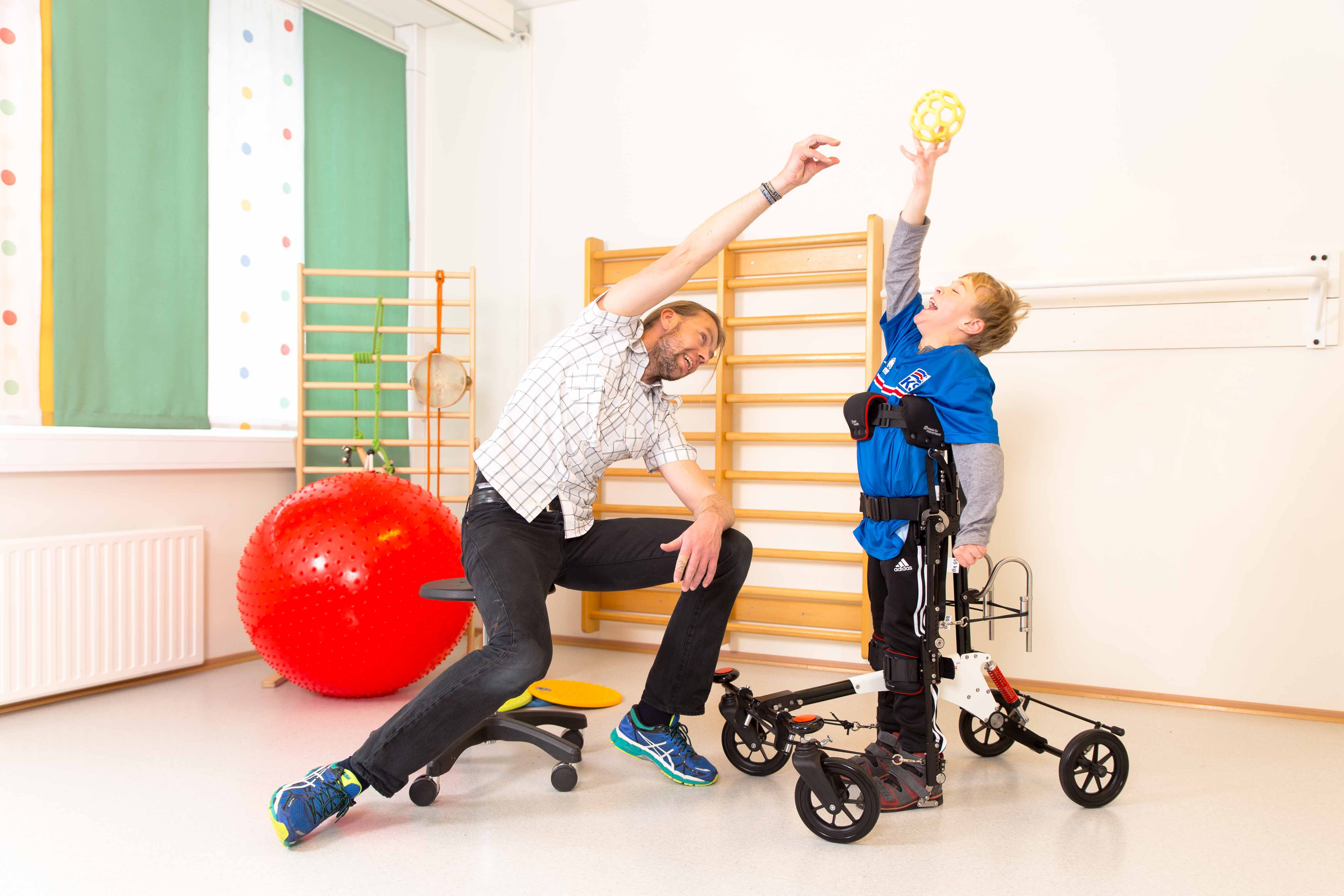 Eldre gutt med personlig assistent leker i NF-Walker