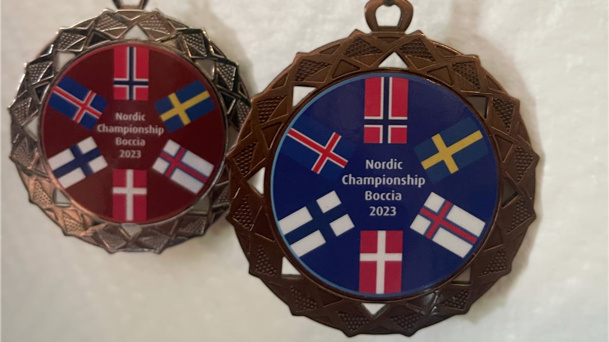 Zwei Medaillen vom Nordic Championship Boccia 2023 mit nordischen Flaggen.