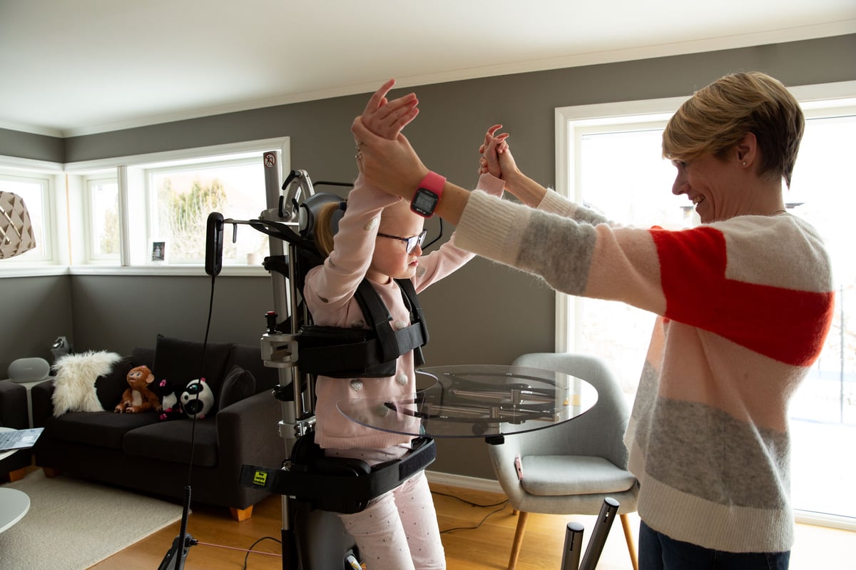 A young girl and her mom delight in interactive moments while standing in the Innowalk