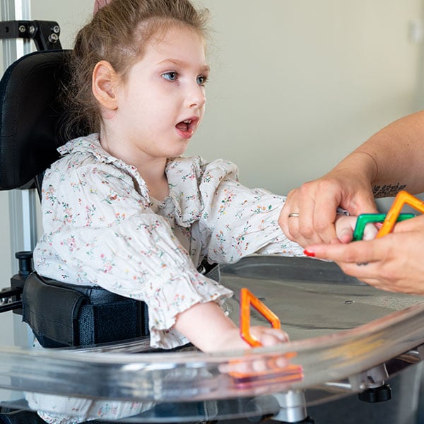 Child standing in the Innowalk Pro with the support tray to support underarms and improve upperbody stability