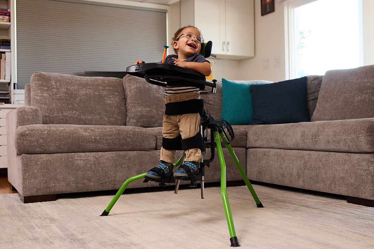 Liten gutt glad og stående i sin Zing Portable